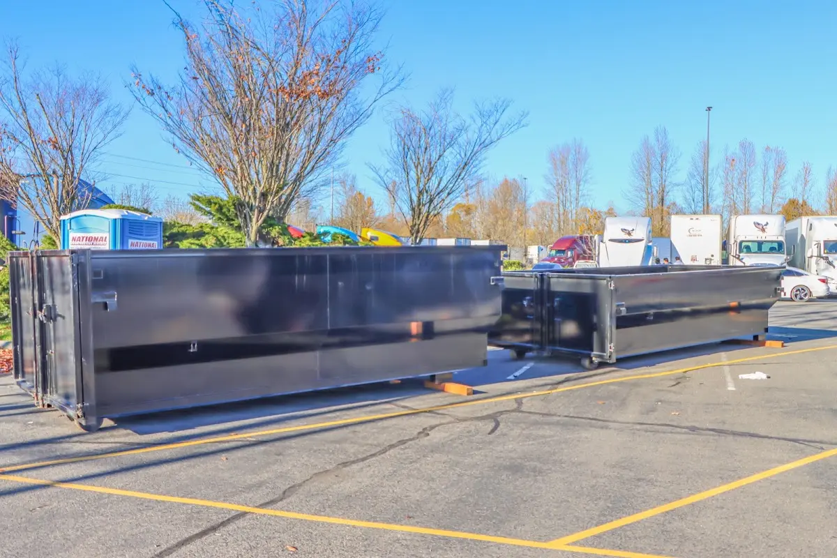 Professional dumpster rental service with roll-off container on residential driveway in Morrilton